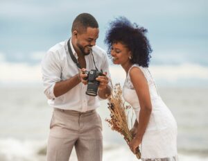 Couple de mariés partageant un moment de bonheur en découvrant leurs photos de mariage sur l'appareil photo, sur une plage des Caraïbes